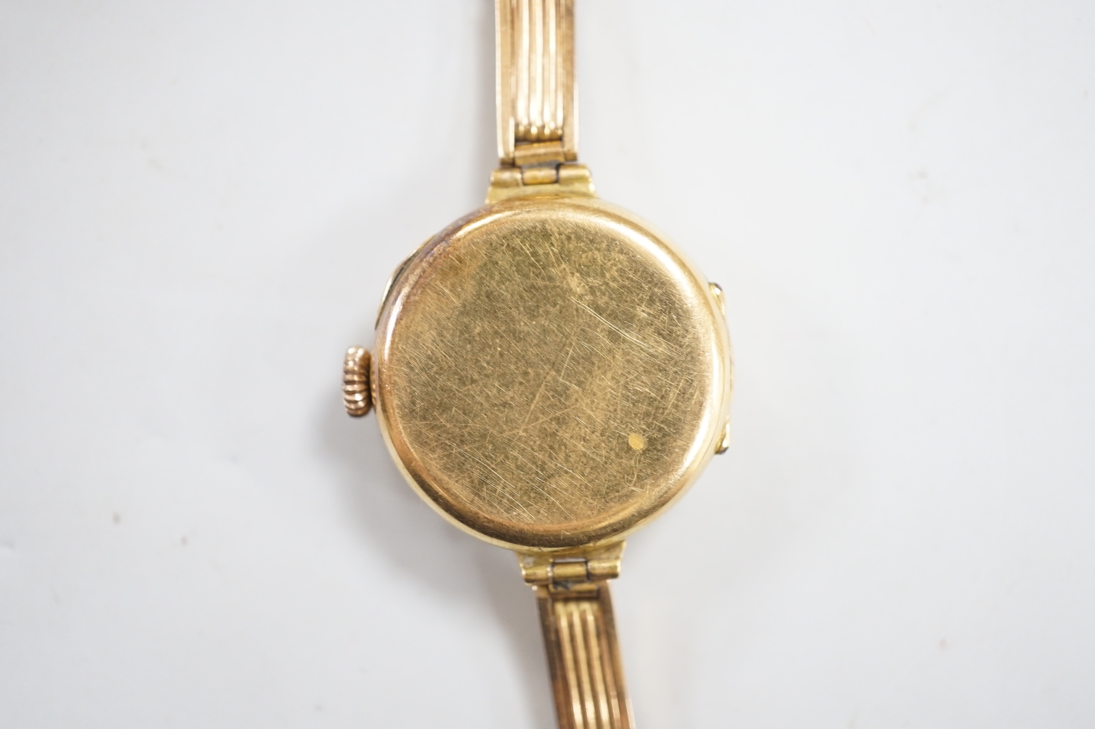 An early 20th century 18ct gold manual wind wrist watch, on an 18ct flexible bracelet, case diameter 25mm, gross weight 25.9 grams.